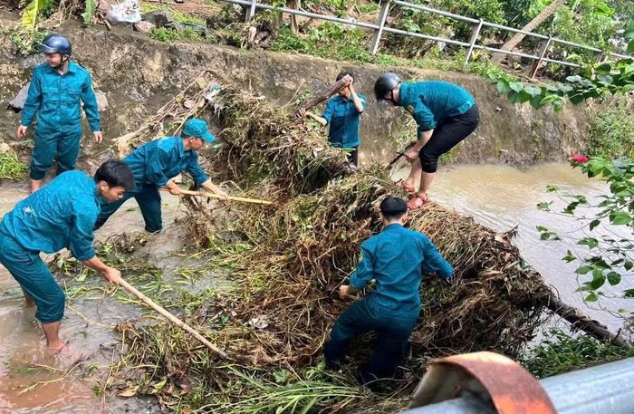Lực lượng dân quân xã Hòa Hội dọn dẹp kênh mương để thoát nước nhanh, chống ngập úng. (Ảnh: LÊ ĐÌNH THÌN).