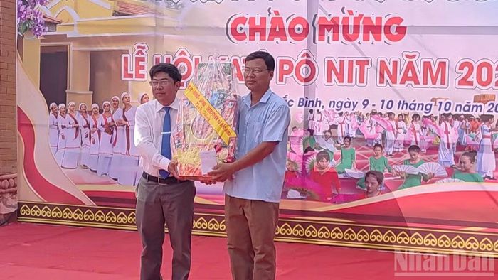 Đồng chí Nguyễn Quốc Thắng, Bí thư Đảng ủy xã Bắc Bình tặng quà cộng đồng người Chăm. (Ảnh: Quý Ngọc)