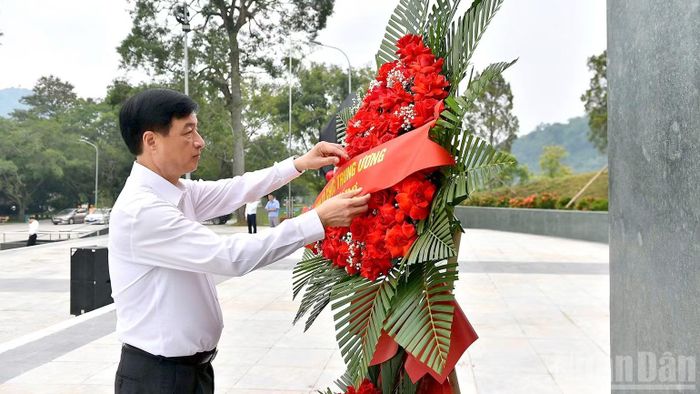 Đồng chí Nguyễn Duy Ngọc chỉnh lẵng hoa trước Tượng đài Bác Hồ ở Tân Trào. (Ảnh: ĐỨC THẲNG)