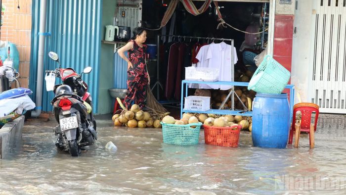Người dân dùng các vật dụng chắn rác theo dòng nước vào nhà.