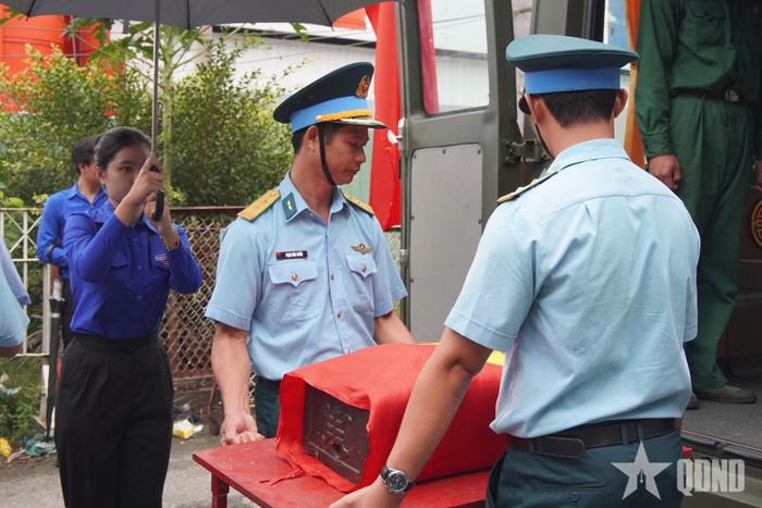  Đoàn viên, thanh niên che ô trong nghi thức di chuyển quách, thể hiện sự trân trọng, lòng thành kính và biết ơn các anh hùng liệt sĩ.  