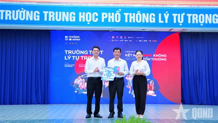 Đồng chí Lê Vinh Liên Trang, Phó trưởng ban Tuyên giáo Tỉnh ủy Khánh Hòa (bên phải) trao cẩm nang chiến dịch tặng Trường THPT Lý Tự Trọng.