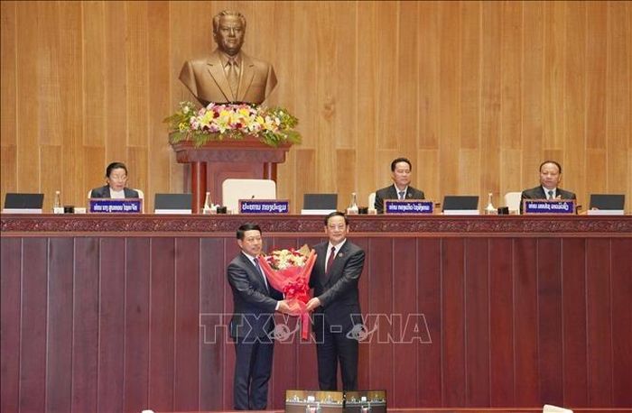 Chủ tịch Quốc hội Lào khóa X Sonexay Siphandone (bên phải) tặng hoa chúc mừng Thủ tướng Chính phủ Lào Saleumxay Kommasit. Ảnh: TTXVN  