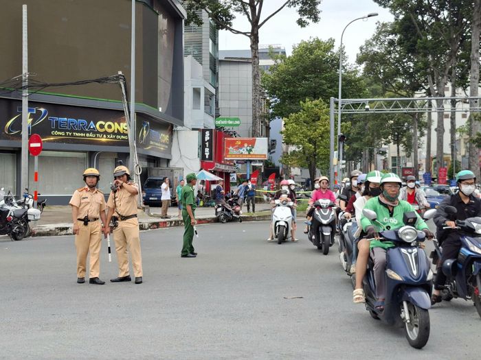  Lực lượng CSGT hướng dẫn người tham gia giao thông tại ngã tư Cách Mạng Tháng Tám - Nguyễn Thị Minh Khai (phường Bến Thành). Ảnh: QUỐC HÙNG 