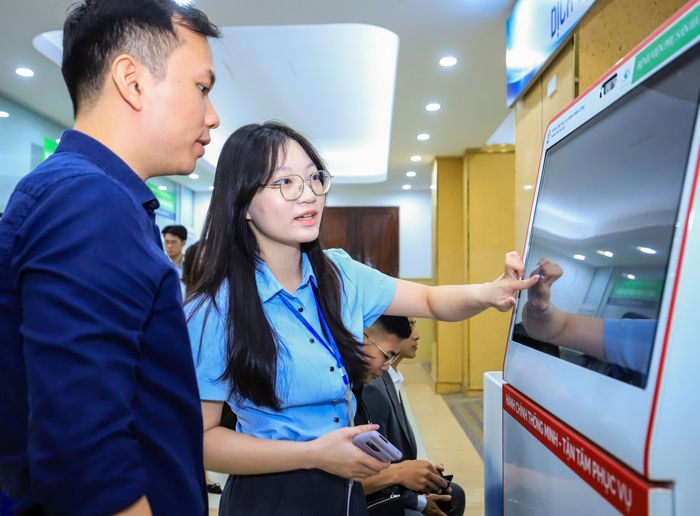 Nhân viên hỗ trợ người dân đăng ký khai sinh tại bệnh viện. Ảnh: THUẬN AN