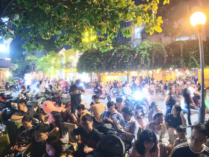  Đông đảo người dân ngồi chờ xem bắn pháo hoa bên hồ Văn Quán. Ảnh: ĐỖ TRUNG 