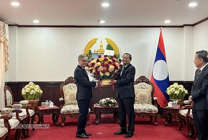 Tổng Lãnh sự Việt Nam tại Savannakhet tăng hoa chúc mừng đồng chí Thongsavanh Phomvihane. (Nguồn: TLSQ Việt Nam tại Savannakhet)