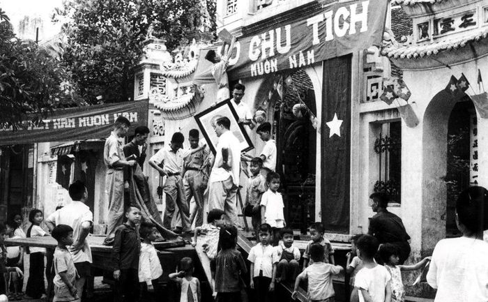 Người dân trang trí đường phố chuẩn bị cho ngày tiếp quản Thủ đô. Ảnh: Tư liệu