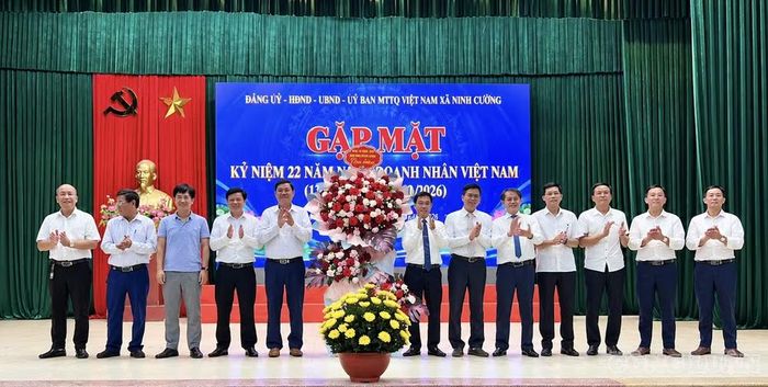 Lãnh đạo Đảng ủy, HĐND, UBND, UBMTTQ xã Ninh Cường tặng hoa chúc mừng cộng đồng doanh nghiệp xã. Ảnh: VT.