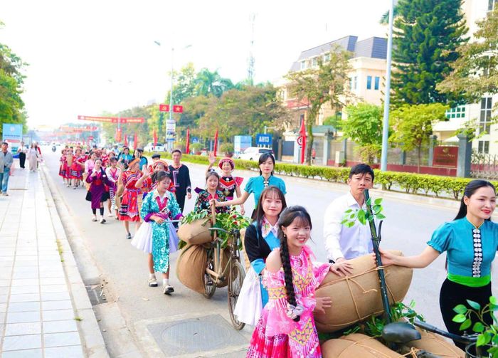 Người dân và du khách trong trang phục truyền thống của đồng bào Mông, Thái tham gia trải nghiệm đẩy xe đạp thồ trên đường Võ Nguyên Giáp.