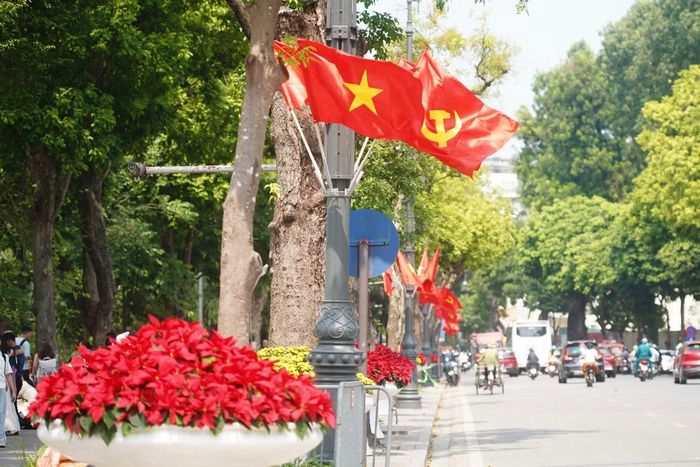 Bồn hoa rực rỡ kết hợp với cụm cờ Tổ quốc, cờ Đảng được đặt dọc các tuyến phố quanh Hồ Hoàn Kiếm.