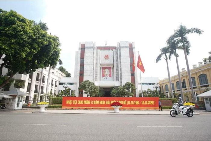 Trước trụ sở UBND TP Hà Nội bên Hồ Hoàn Kiếm, cờ Tổ quốc tung bay và pa-nô "Nhiệt liệt chào mừng 72 năm Ngày Giải phóng Thủ đô (10/10/1954 - 10/10/2026).