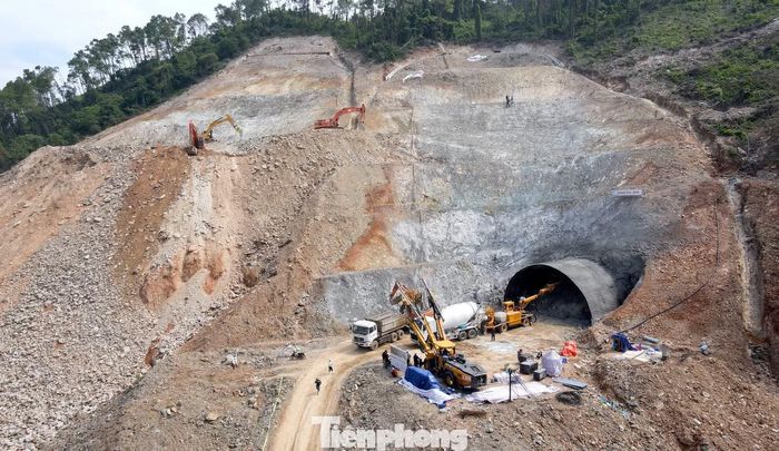 Sau khi khoan phá, đất đá được máy xúc thu gom, vận chuyển ra ngoài. Các lực lượng thi công tiếp tục dựng vì, gia cố mái hầm bằng sắt và bê tông.