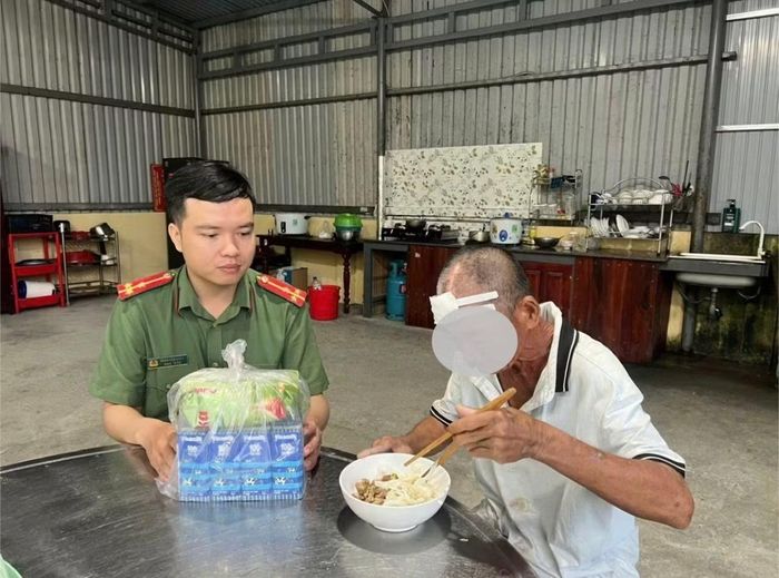 Công an xã Điện Bàn Tây hỗ trợ ăn uống, chăm sóc cho người đàn ông trong khi chờ xác minh thông tin. Ảnh CA