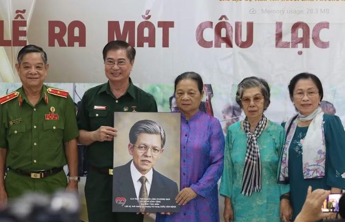 Hai con gái của Anh hùng Lực lượng vũ trang nhân dân Châu Văn Đặng xúc động đón nhận di ảnh phục dựng của cha. Ảnh: Vĩnh Hy