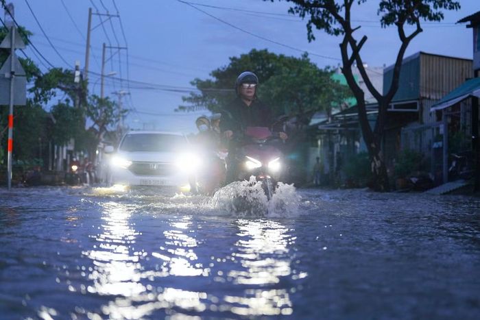 Nhiều xe máy chật vật vượt qua dòng nước.