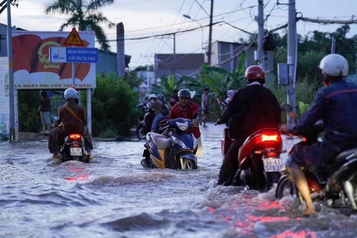 Không ít người phải xuống xe, dắt bộ qua đoạn ngập sâu. Việc di chuyển gặp nhiều khó khăn khi nước che khuất mặt đường và lề đường.