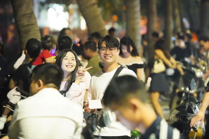 Người dân ngồi dọc ven hồ Tây, chờ đón màn trình diễn ánh sáng trên bầu trời Thủ đô.