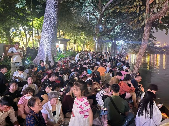 Các vị trí thuận lợi quanh hồ Hoàn Kiếm gần như kín chỗ. Nhiều người mang theo đồ ăn nhẹ, nước uống để chờ đợi màn pháo hoa.