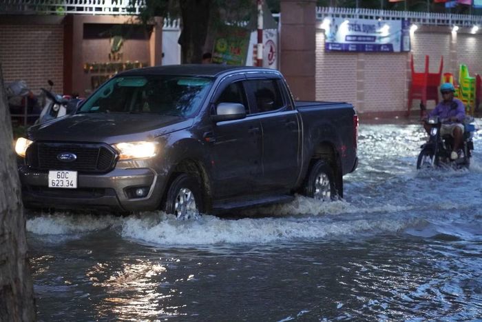 Triều cường lên nhanh, nước không lối thoát, người dân di chuyển gặp nhiều khó khăn.