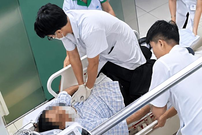 Bác sĩ Nguyễn Tuấn Quang khẩn trương ép tim cho bệnh nhân ngừng tuần hoàn ngay trên băng ca, nỗ lực giành lại sự sống trong thời khắc nguy kịch.