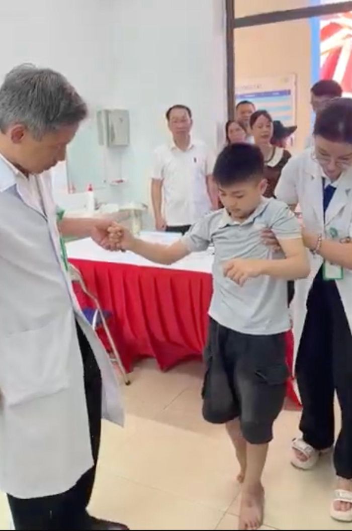 Bé T. được dìu đi lại, đứng lên ngồi xuống. Ảnh cắt từ clip