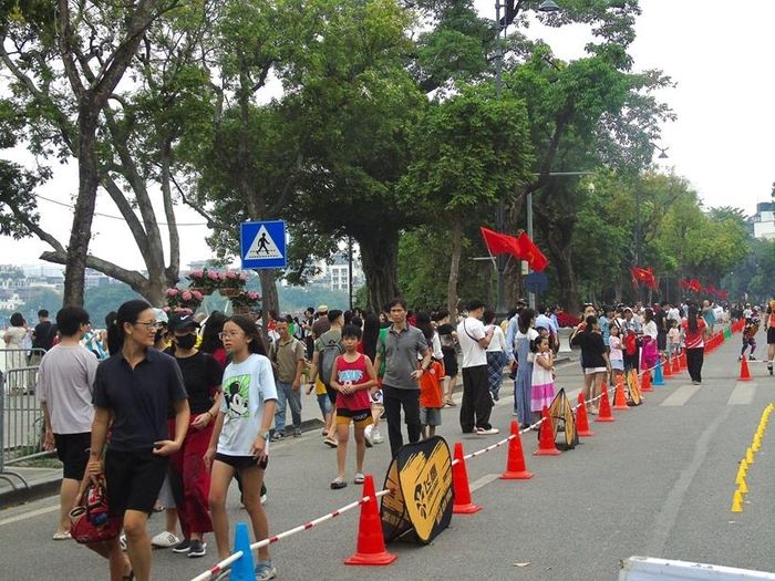 Đông đảo người dân và du khách tập trung quanh hồ Hoàn Kiếm, tranh thủ dạo chơi, chụp ảnh.