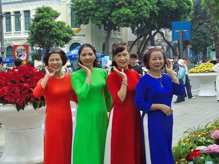Người dân trong trang phục áo dài truyền thống lưu giữ những khoảnh khắc kỷ niệm ngày 10/10.