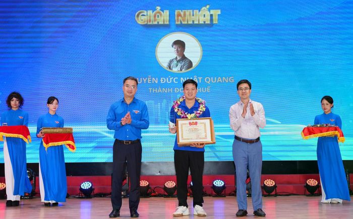 Anh Nguyễn Tường Lâm - Bí thư Trung ương Đoàn và anh Bùi Hoàng Tùng - Bí thư Đoàn Thanh niên Chính phủ trao giải nhất cho thí sinh Nguyễn Đức Nhật Quang (Thành đoàn Huế). Ảnh: BTC hội thi.
