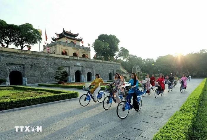 Với cộng đồng quốc tế, Thủ đô Hà Nội là một thành phố luôn phát triển năng động nhưng vẫn giữ những nét truyền thống. Trong ảnh: Phụ nữ Thủ đô trong trang phục áo dài đạp xe qua các điểm di sản của Hà Nội trong “Áo dài kết nối du lịch và di sản Hà Nội lần thứ nhất - năm 2023.” (Ảnh: Nhật Anh/TTXVN)