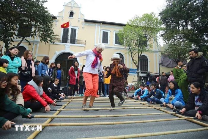 Một trong những lý do khiến du khách quốc tế có cảm tình với Hà Nội là thái độ niềm nở, thân thiện của người dân Thủ đô. Trong ảnh: Du khách quốc tế tham gia các hoạt động văn hoá tại không gian đi bộ quanh hồ Hoàn Kiếm. (Ảnh: Thành Đạt/TTXVN)