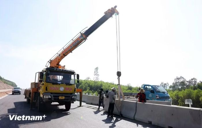 Công nhân lắp dải phân cách giữa của tuyến cao tốc. (Ảnh: Việt Hùng/Vietnam+)