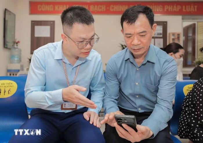 Người dân được hướng dẫn nộp hồ sơ trực tuyến qua điện thoại. (Ảnh: Phan Phương/TTXVN)