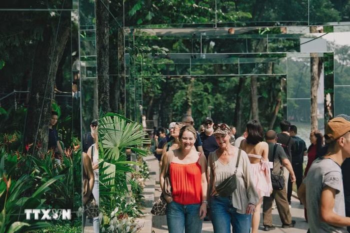 Du khách quốc tế tham quan, dạo bước giữa hệ thống khung gương nghệ thuật tại không gian “Dải lụa ký ức” bên hồ Hoàn Kiếm. (Ảnh: Phạm Tuấn Anh/TTXVN)