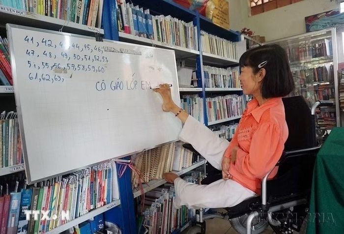 Mặc dù bị liệt hai tay và một chân, nhưng chị Huỳnh Thị Xậm (quê Hậu Giang) đã nỗ lực vượt lên chính mình. Bên cạnh công việc nhân viên thư viện tại Trung tâm dạy nghề cho người khuyết tật và trẻ mồ côi Thành phố Hồ Chí Minh, chị còn là một “cô giáo” đặc biệt của những học viên có độ tuổi từ 15-35 tuổi chưa biết chữ. (Ảnh: Thu Hoài/TTXVN)