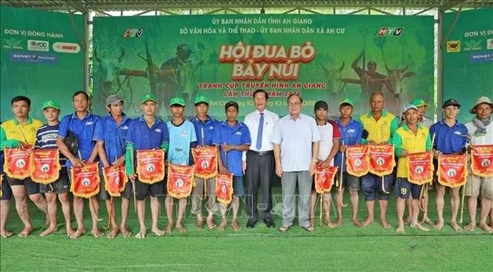 Ban tổ chức trao cờ lưu niệm cho chủ các đôi bò tham gia thi đấu tại Hội đua bò Bảy Núi tỉnh An Giang năm 2026.