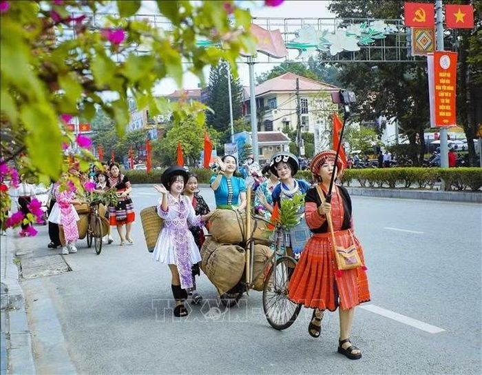 Người dân trong trang phục truyền thống của đồng bào Mông, Thái tham gia trải nghiệm đẩy xe đạp thồ trên đường Võ Nguyên Giáp.