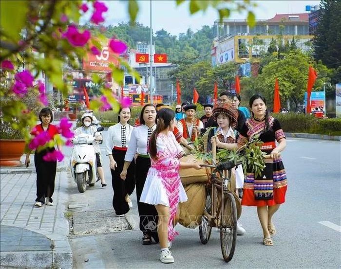 Đoàn người trong trang phục truyền thống tham gia trải nghiệm đẩy xe đạp thồ, tái hiện một hình ảnh hậu cần đặc biệt trong Chiến dịch Điện Biên Phủ.