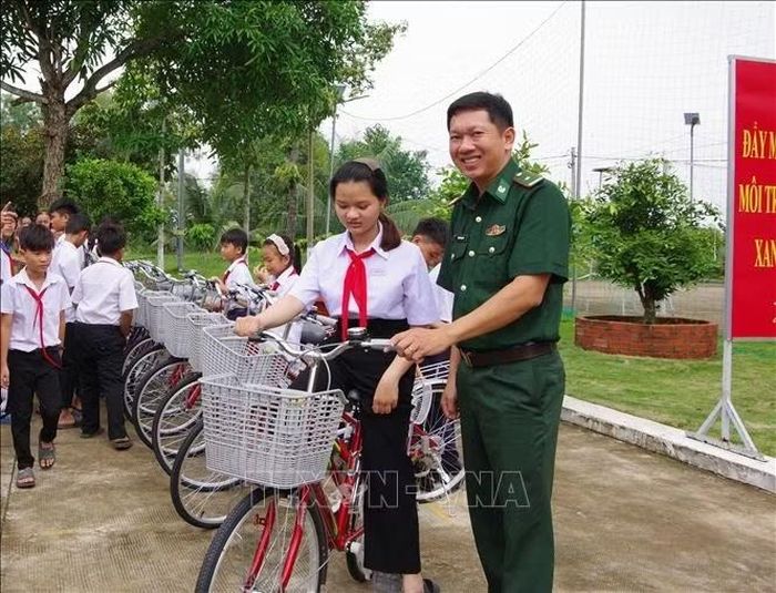 Cán bộ Bộ đội Biên phòng hướng dẫn, hỗ trợ các cháu điều khiển xe về nhà. Ảnh: TTXVN phát