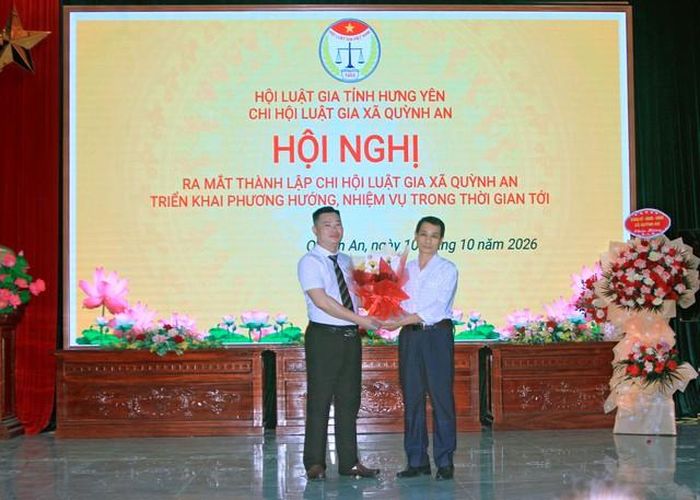 Ông Bùi Khắc Tứ, Chi hội trưởng Chi hội Luật gia xã Quỳnh An nhận hoa chúc mừng từ đại diện doanh nghiệp.