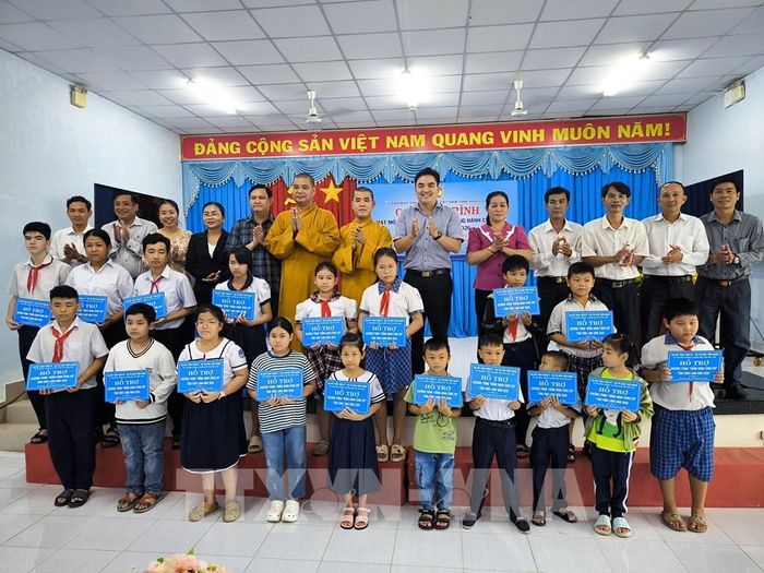 Trao biểu trưng hỗ trợ kinh phí hàng tháng cho trẻ em tại chương trình. Ảnh: Huỳnh Phúc Hậu - TTXVN