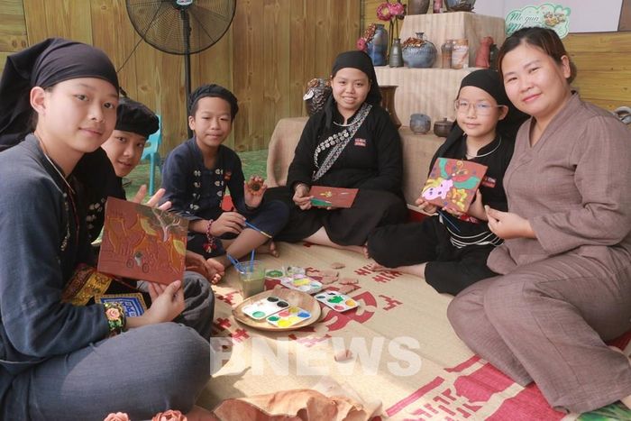 Chị Đoàn Minh Ngọc (áo nâu) tại gian trưng bày sản phẩm. Ảnh: Thanh Hà
