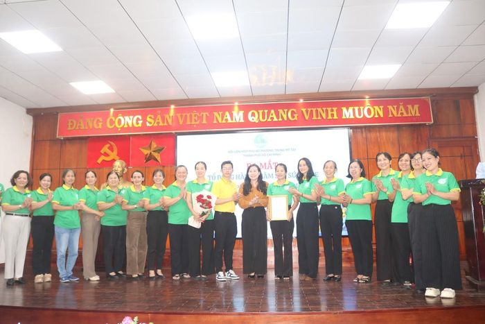 Các thành viên Tổ đồng hành chăm sóc sức khỏe phường Trung Mỹ Tây nhận quyết định thành lập và hoa chúc mừng.