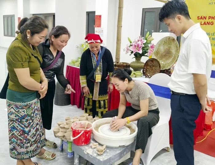  Người dân làng gốm Phù Lãng hướng dẫn du khách nặn gốm. 