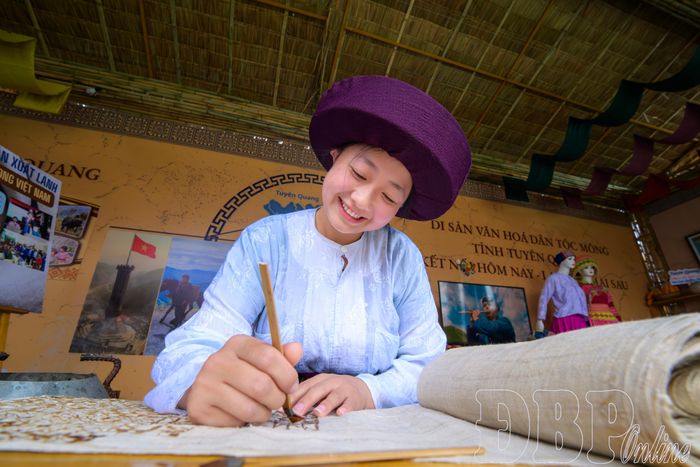 Em Ly Thị Cở, đoàn tỉnh Tuyên Quang trình diễn vẽ hoa văn bằng sáp ong.