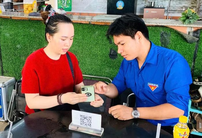 Tổ công nghệ số cộng đồng hướng dẫn các hộ kinh doanh tiếp cận các tiện ích số. Ảnh: Ánh Nguyệt