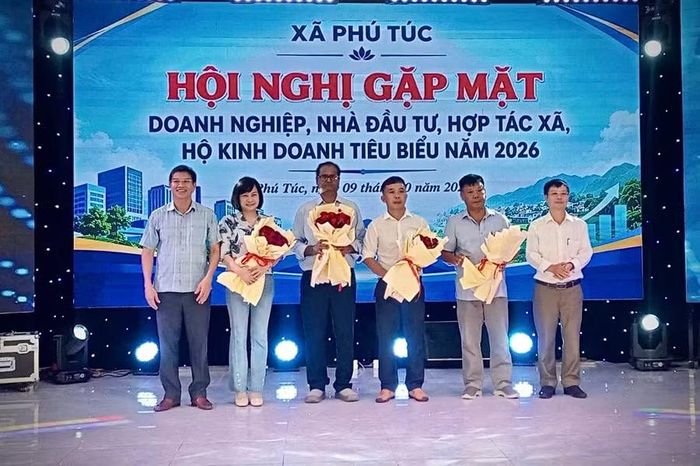  Đại diện lãnh đạo xã Phú Túc tặng hoa chúc mừng các doanh nghiệp tiêu biểu có những đóng góp tích cực đối với địa phương. Ảnh: Văn Chi 