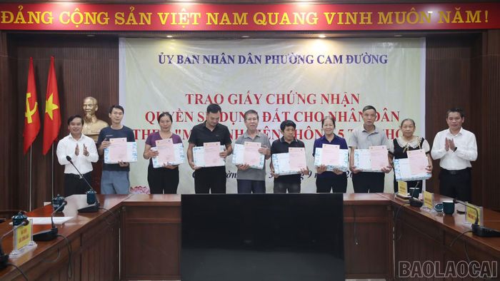Lãnh đạo phường Cam Đường trao giấy chứng nhận quyền sử dụng đất cho người dân.