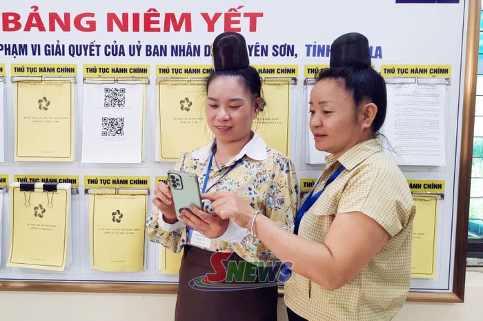 Cán bộ Trung tâm Phục vụ hành chính công xã Yên Sơn hướng dẫn nhân dân quét mã QR tra cứu TTHC.