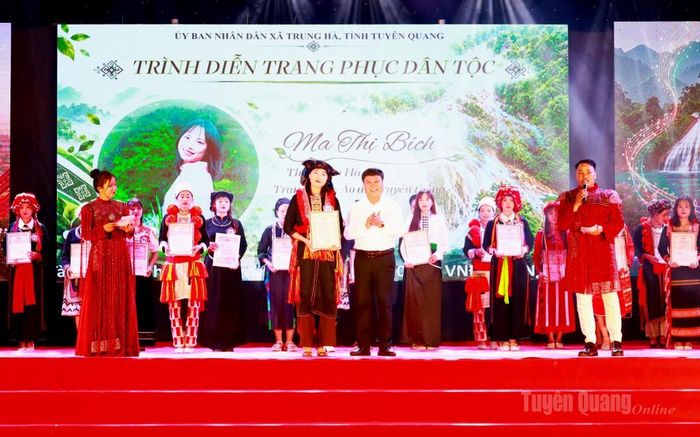 Đồng chí Mai Đức Thông, Ủy viên Ban Chấp hành Đảng bộ tỉnh, Giám đốc Báo và phát thanh, truyền hình Tuyên Quang, Chủ tịch Hội Nhà báo tỉnh trao giải Nhất thi trình diễn trang phục dân tộc cho thí sinh Ma Thị Bích, thôn Tân Hà.